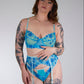 Woman wearing a blue patterned lingerie against a plain background