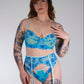 Woman wearing a blue floral lingerie set against a plain background