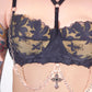 Black lace bra with floral patterns and chain details on a white background
