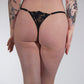 Person wearing black lace lingerie against a plain background