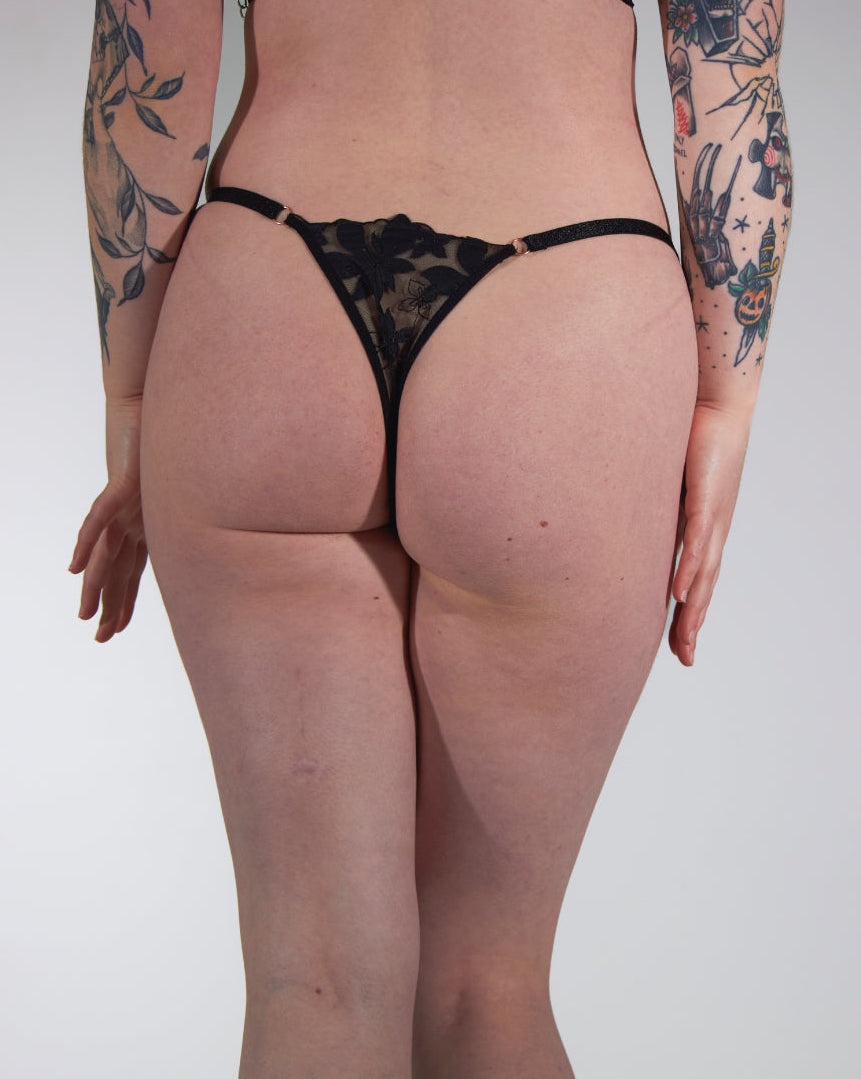 Person wearing black lace lingerie against a plain background