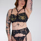 Person wearing a black lace lingerie set on a plain background