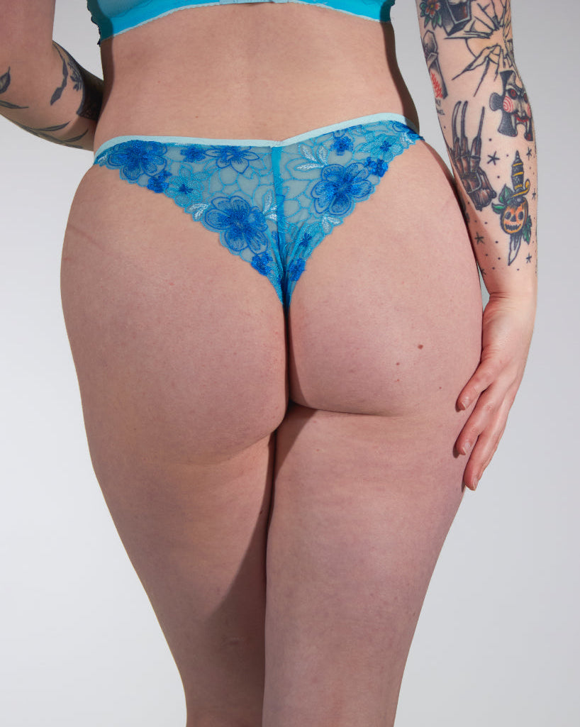 Person wearing blue floral underwear against a plain background