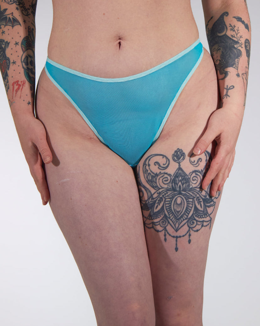 Person wearing blue lingerie bottom on a plain background