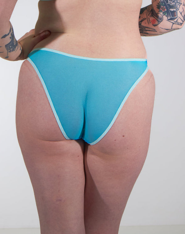 Person wearing a light blue lingerie against a plain background
