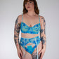 Person wearing a blue floral lingerie set against a plain background
