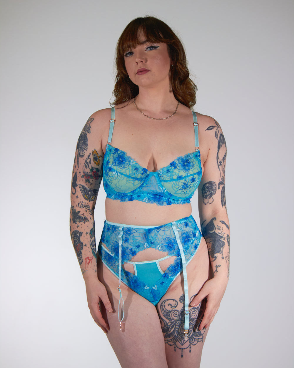 Person wearing a blue floral lingerie set against a plain background