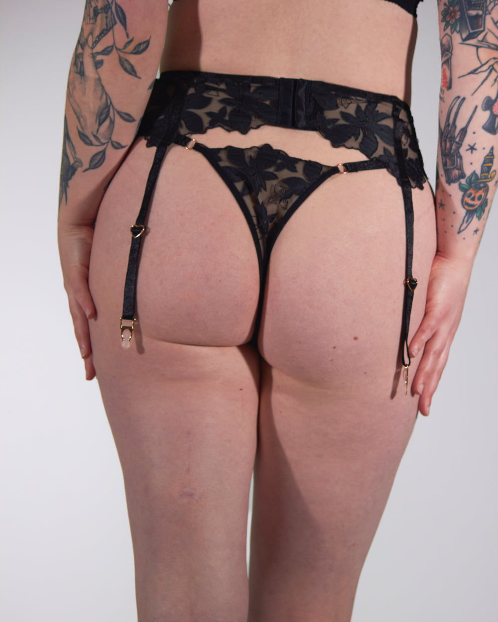 black lace garter belt with chains on a white background